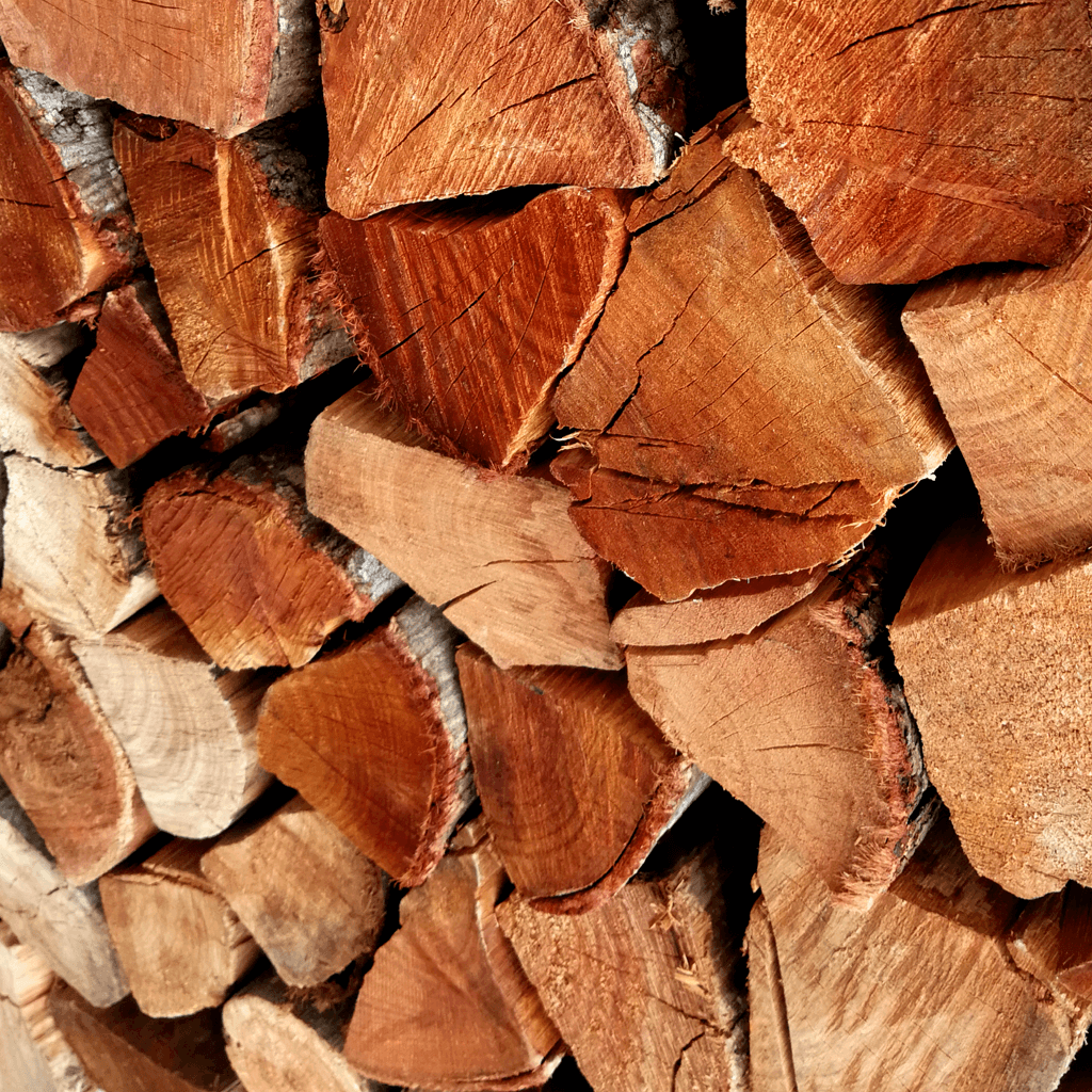 Close-up shot of dry Black Wattle firewood logs stacked for indoor fireplace heating