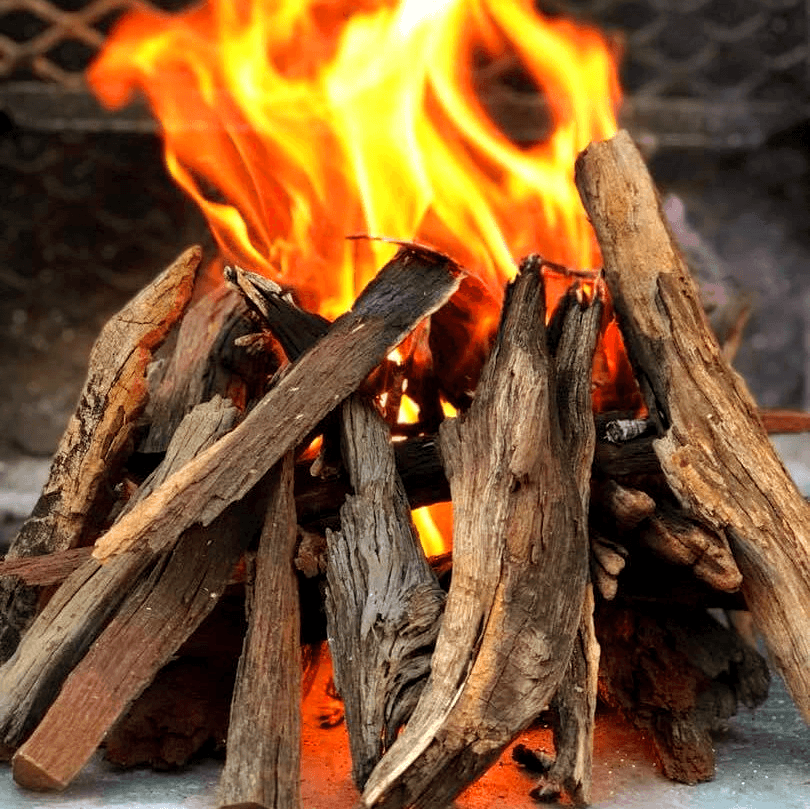 Stacked and burning desert wood kindling from Namibian Hardwood Firestarter Bags creating a strong base fire