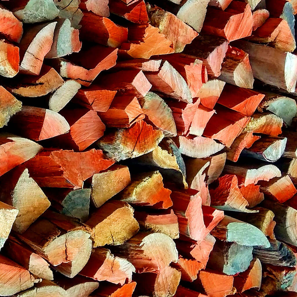 Dry Red Gum firewood logs stacked for fireplace heating and long-burning braai coals.