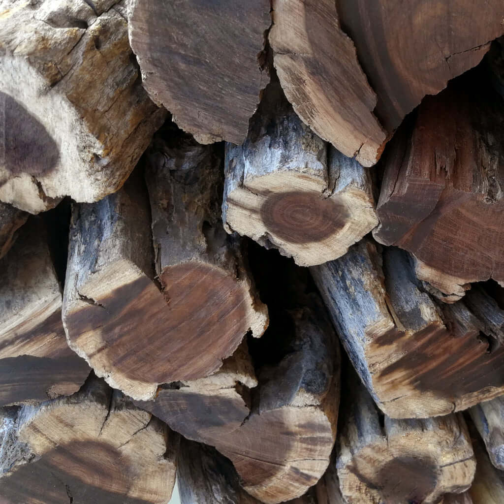 Close-up of dry Swarthaak logs with no bark showing dense grain and natural seasoning